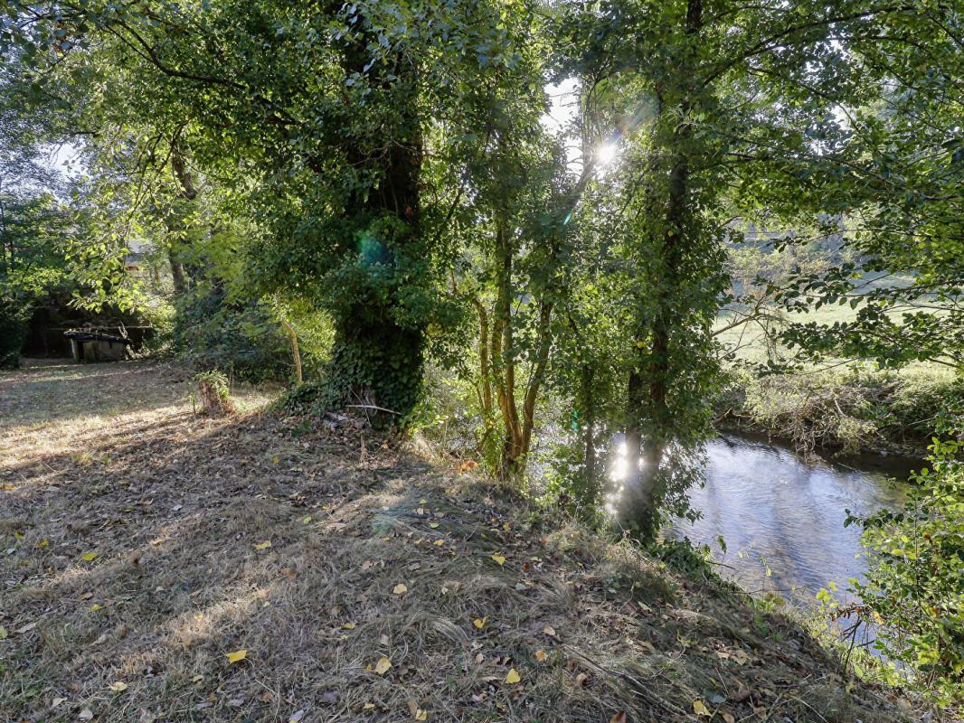 Maison 3 chambres avec grande terrasse et terrain de 2 300 m² bordé par une rivière
